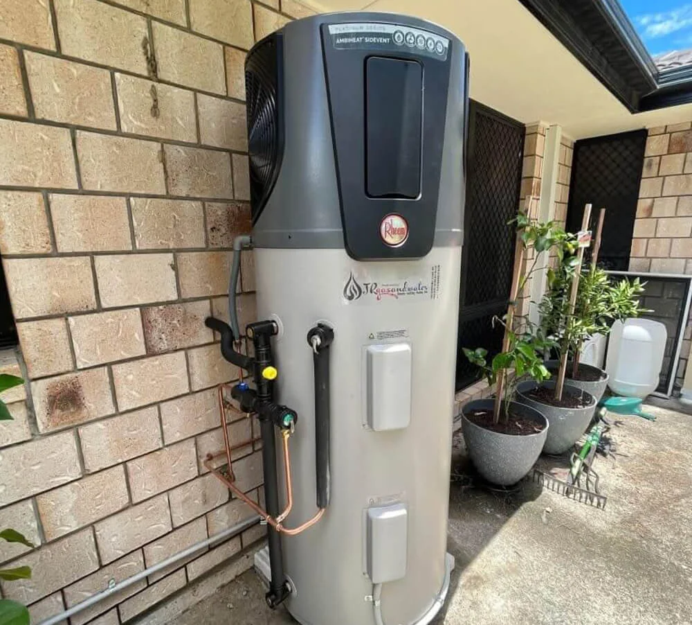 Water heater beside a brick wall